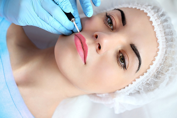 Cosmetologist applying permanent make up on lips - Фото, зображення