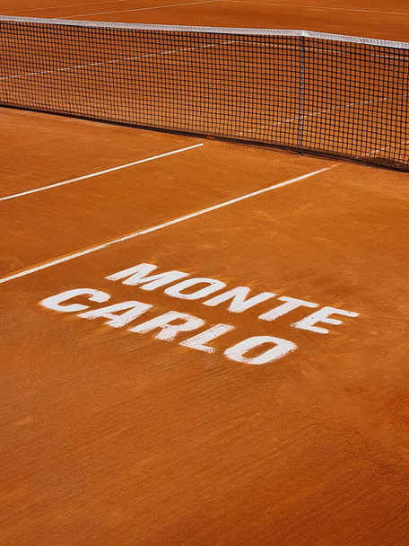 Una veduta ravvicinata del caratteristico campo in argilla arancione al prestigioso torneo di tennis Monte-Carlo Masters, con le linee bianche e la rete - Foto, immagini