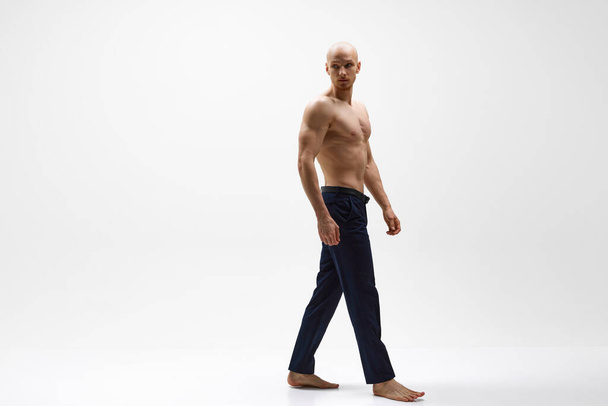 Full length portrait of young half-naked athletic man posing against grey studio background. Concept of mens health, self care, fashion and beauty, healthy lifestyle. Ad - Photo, Image