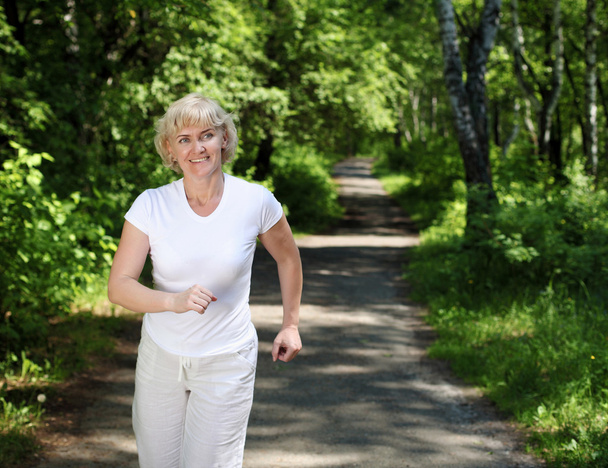 Elderly woman likes to run in the park - Valokuva, kuva