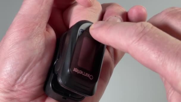 Activar el oxímetro de pulso aplicado al dedo de una persona - Metraje, vídeo