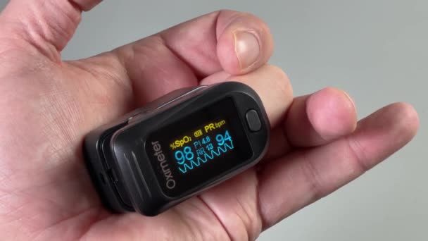 Oxímetro de pulso en el dedo de la persona durante la medición de la saturación de oxígeno en sangre - Metraje, vídeo