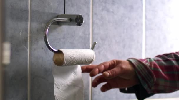 Hand krijgen toilet loo rol in de badkamer close-up zoom schot slow motion selectieve focus  - Video