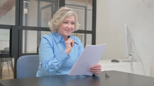 Senior oude vrouw viert nieuw contract in kantoor - Video