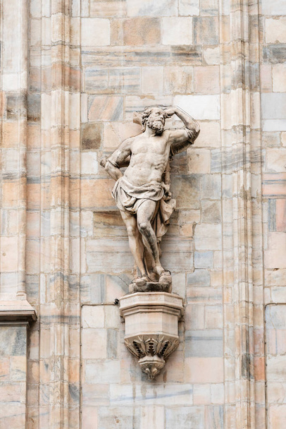 Μιλάνο, Ιταλία - 30 Αυγούστου 2022: Γοτθικά μαρμάρινα αγάλματα στον καθεδρικό ναό του Μιλάνου Duomo, έξω από τα αγάλματα διακόσμησης. Μεγαλύτερη εκκλησία στην Ιταλία και δημοφιλή τουριστικό αξιοθέατο. - Φωτογραφία, εικόνα