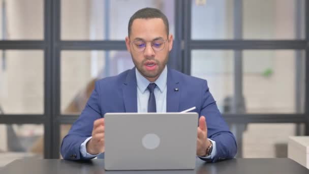 Uomo d'affari di razza mista che fa video chat via computer portatile - Filmati, video