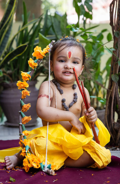 Ritratto di carino indiano ragazzo abiti da lord rama con fiocco all'aperto con sfondo sfocato di giorno - Foto, immagini