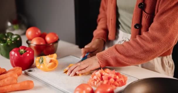 Kädet, nainen ja leikkaa vihanneksia ruoanlaittoon ruokavaliolla, ravitsemuksella ja maulla kotona. Naishenkilö, leikkaus ja kasvisruoka terveelliseen ateriaan ainesosilla tai resepteillä keittoon - Materiaali, video