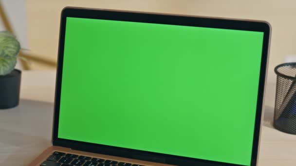 Современный ноутбук с зеленым экраном расположен на офисном столе крупным планом. Вид включенного макета ноутбука с зеленым экраном готов для работы компании. Пустой дисплей с хроматическим ключом на светлом корпоративном рабочем месте - Кадры, видео