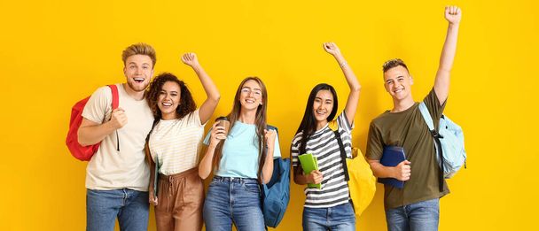 Retrato de jóvenes estudiantes felices sobre fondo amarillo - Foto, imagen
