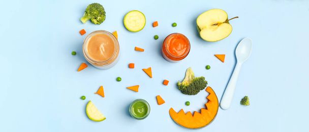 Jars of healthy baby food and ingredients on blue background - Photo, Image