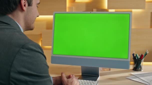 Формальний хлопець, який має комп'ютер із зеленим екраном, жестикулює руками в офісі крупним планом. Щасливий усміхнений режисер розмовляє онлайн макетним монітором. Бос дивиться ключ хромосоми ПК робить віртуальну конференцію збільшити масштаб - Кадри, відео