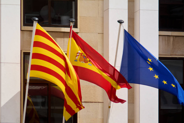 De vlaggen van Spanje, Catalonië en Europa wapperen in de wind en symboliseren eenheid, diversiteit en coëxistentie in de Europese Gemeenschap.. - Foto, afbeelding