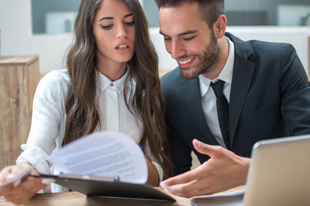 Close up portrait of beautiful attractive business woman and handsome business man discussing documents during a meeting in office - Photo, Image