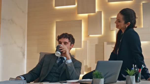 Korporátní pár si užívá přestávku v pozdním záběru. Obchodní partneři, kteří pijí kávu, mluví v béžové skříni. Sedící obchodník držící skříňku. Dva kolegové odpočívají spolu  - Záběry, video