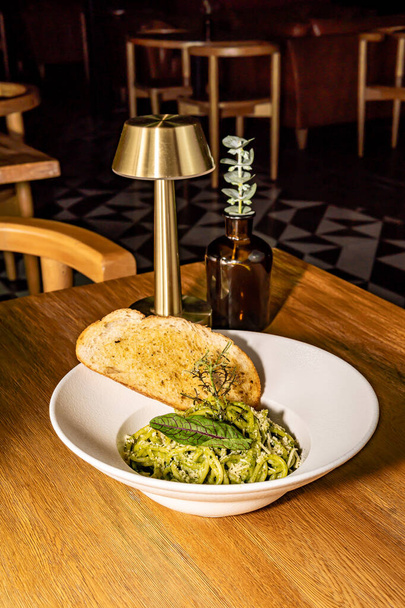 Pasta verde con parmigiano e pane speziato. Pesto e spinaci. Ristorante dell'hotel gourmet. - Foto, immagini