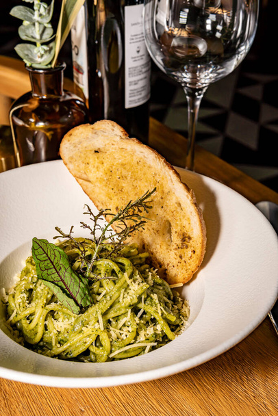 Grüne Nudeln mit Parmesan und gewürztem Brot. Pesto und Spinat. Gourmet-Hotelrestaurant. - Foto, Bild
