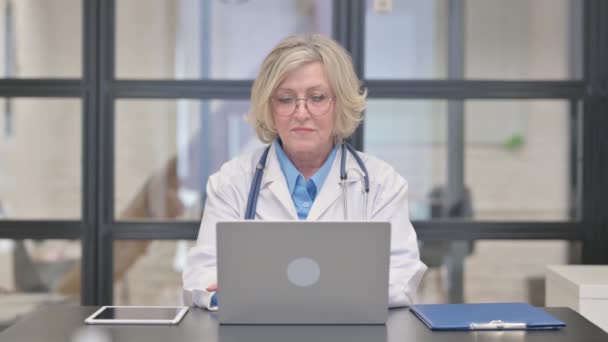 Chiamami Gesto dal vecchio medico femminile che lavora sul computer portatile - Filmati, video
