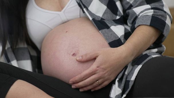 Myöhään vaiheessa raskaus - Nainen hyväilee vatsa lähikuva, kolmannen kolmanneksen mukavuutta - Valokuva, kuva
