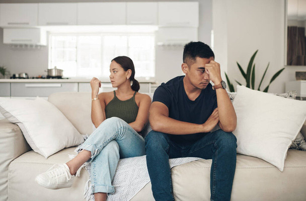 Divorce, angry or couple fight on sofa with anxiety, fear or frustrated by liar, stress or drama at home. Marriage, conflict or asian people argue in living room with blame, overthinking or mistake. - Photo, Image