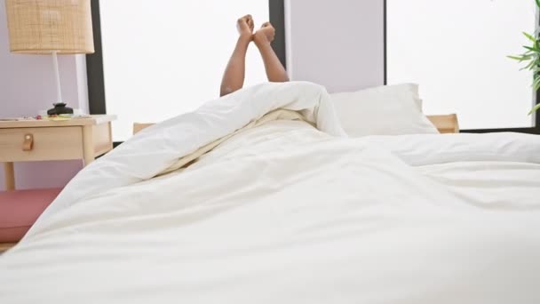 Parlak bir yatak odasında kollarını uzatan yetişkin bir kadın rahatlama ve sabah tazeliği hissi yaratıyor.. - Video, Çekim