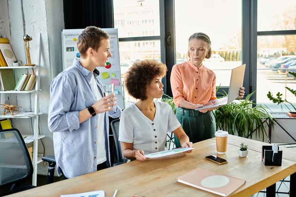 Vielfältige Gruppe fleißiger Geschäftsfrauen trifft sich an einem Holztisch in einem Coworking Space. - Foto, Bild