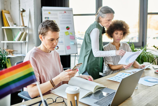Empenhadas diversas mulheres de negócios, incluindo membros da comunidade LGBT, trabalhando juntas em um escritório. - Foto, Imagem