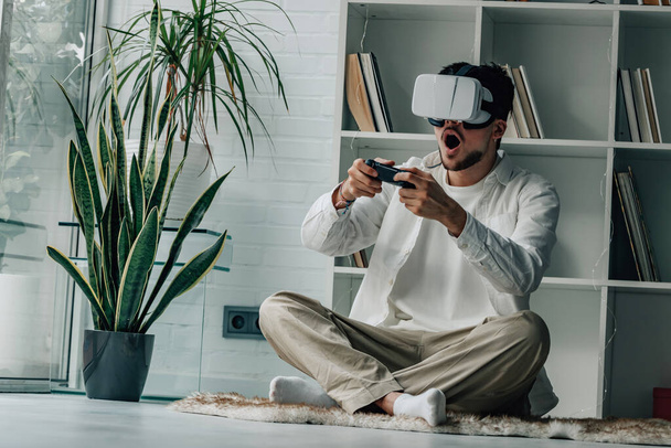 mladý muž doma s brýlemi virtuální reality a joystickem - Fotografie, Obrázek
