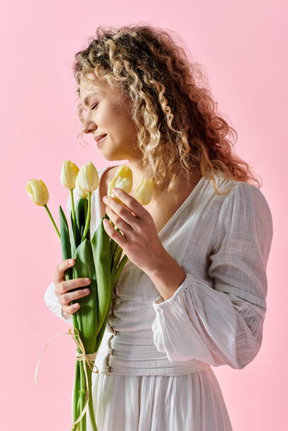 Nő fehér ruha kezében friss tulipán csokor. - Fotó, kép