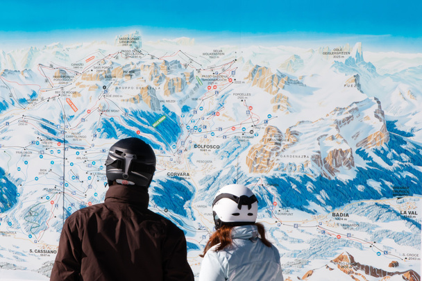 esquiadores com capacetes de segurança em frente ao mapa de esqui
 - Foto, Imagem