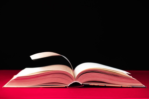 Pagina 's van een dik boek zijn gedraaid op een roze en zwarte achtergrond, ruimte voor tekst - Foto, afbeelding