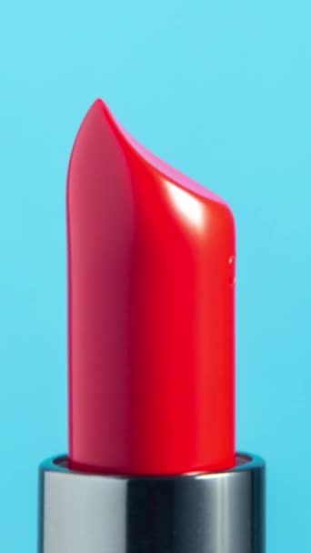 Imágenes de primer plano de lápiz labial de color brillante girando contra un fondo blanco liso en formato vertical - Metraje, vídeo