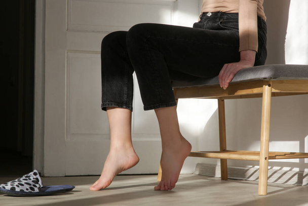 Barefoot vrouw op de houten vloer. Begrip vloerverwarming in het appartement. - Foto, afbeelding