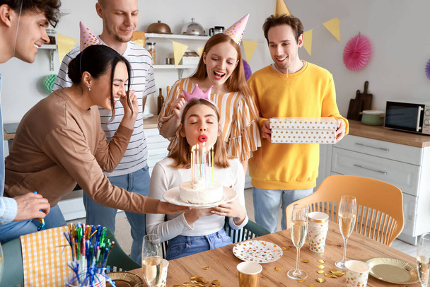 Nuori nainen tekee toiveen syntymäpäiväjuhlissa ystäviensä kanssa - Valokuva, kuva