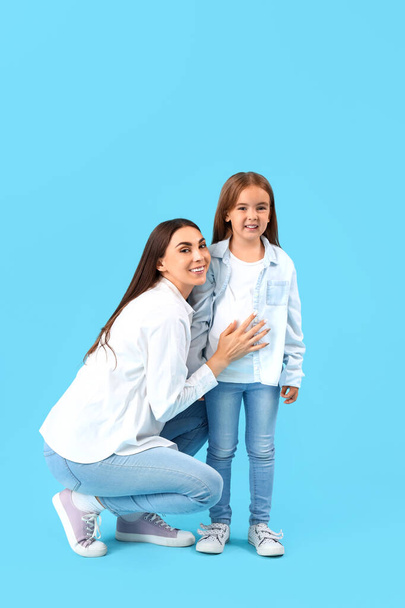 Boldog anya a kislányával a kék háttérben - Fotó, kép