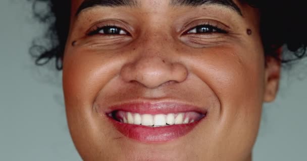 Een vrolijke jonge zwarte Braziliaanse vrouw van Afrikaanse afkomst glimlachen op camera in strakke macro close-up gezichtsdetail glimlach met vriendelijke houding - Video