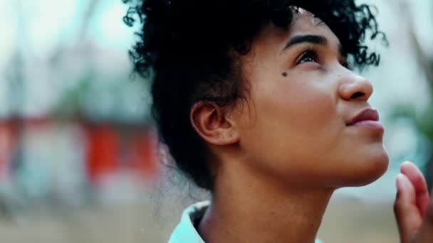 Wdzięczna młoda Afroamerykanka spoglądająca w górę Modląc się do Boga i czując się duchowo połączona z wyższą mocą - Materiał filmowy, wideo