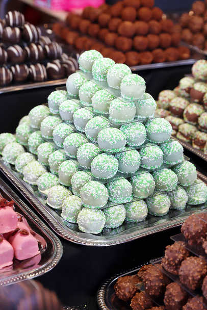Chocolade marsepein snoepjes gevuld verschillende smaken. Zoetballen gebouwd als piramide voor sle in een banketbakkerij - Foto, afbeelding