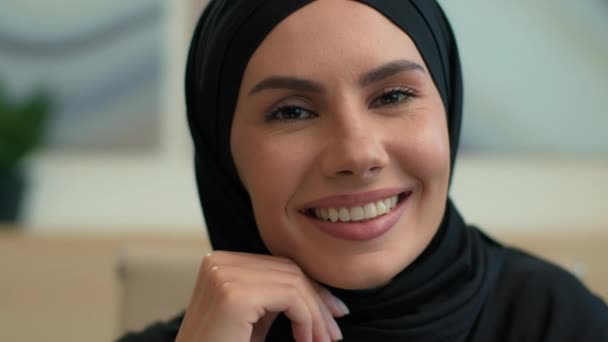 Gros plan portrait heureux Arabe musulman islamique femme en hijab noir à l'intérieur souriant gai visage féminin dentaire dents sourire sourire à la caméra joyeuse fille Islam religion foi mode orientale beauté - Séquence, vidéo