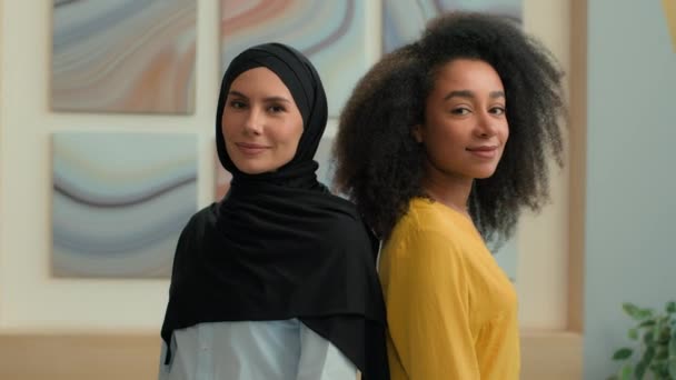 Retrato corporativo parceiros de negócios multirraciais felizes colegas mulheres de negócios no escritório sorrindo diversas mulheres afro-americanas e árabes muçulmanas meninas islâmicas no hijab posando mãos cruzadas trabalho em equipe - Filmagem, Vídeo