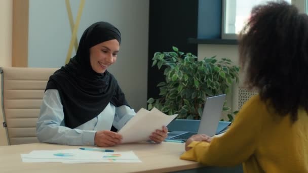 Arabo musulmana donna islamica in hijab investitore donna datore di lavoro firma documento di contratto concludere accordo di affari partenariato donna d'affari e la cooperazione con i clienti donne multirazziali in carica - Filmati, video