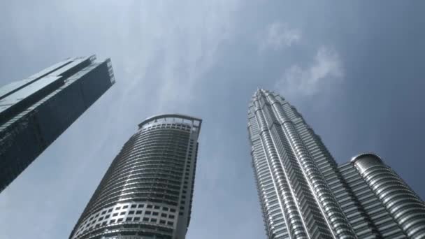 August 15,2022.Kuala lumpur,Malaysia.low angle view upto the highrise financial skyscraper tall modern glasses design building against clear blue sky under sunshine day, financial district tower - Filmmaterial, Video