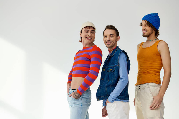 alegre boa aparência lgbtq amigos masculinos em roupas vibrantes casuais posando ativamente no fundo cinza - Foto, Imagem
