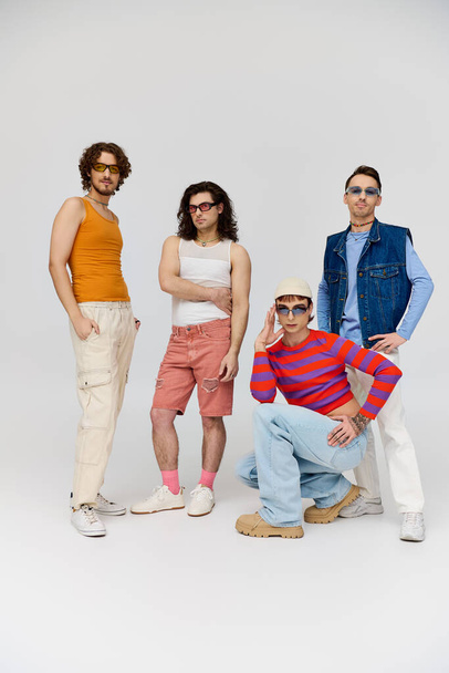 четыре симпатичных весёлых друга-гея в стильных солнцезащитных очках, позирующих вместе, месяц гордости - Фото, изображение