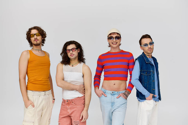 quatre beaux amis gays joyeux avec des lunettes de soleil élégantes posant activement ensemble, mois de fierté - Photo, image