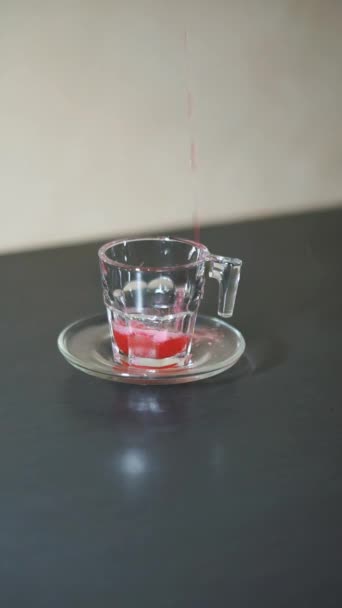 piękny pionowy portret wideo Czerwony napój jest wlewany do białego szkła - Materiał filmowy, wideo