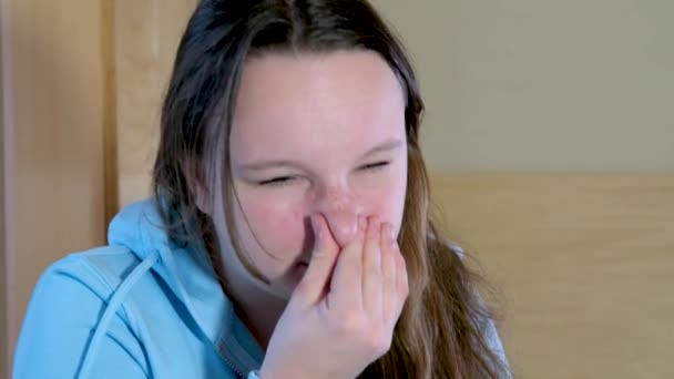 Mulher a espirrar. uma jovem adolescente em uma blusa azul espirra alergias sazonais olhos lacrimejantes Imagens de alta qualidade 4k - Filmagem, Vídeo