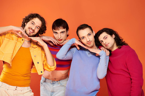 cheerful voguish gay men with makeup in vibrant attires posing actively together, pride month - Fotografie, Obrázek