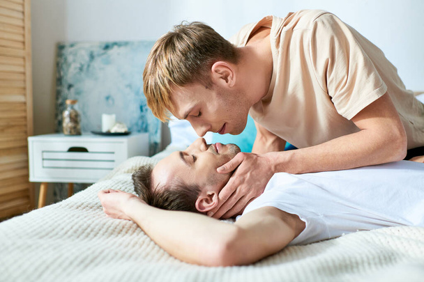Dois homens pacificamente abraçam-se em uma cama em trajes casuais. - Foto, Imagem