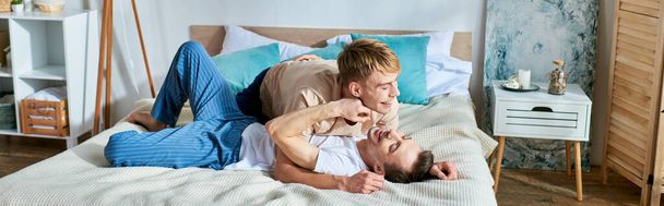 Два чоловіки в повсякденному вбранні лежать разом на ліжку. - Фото, зображення